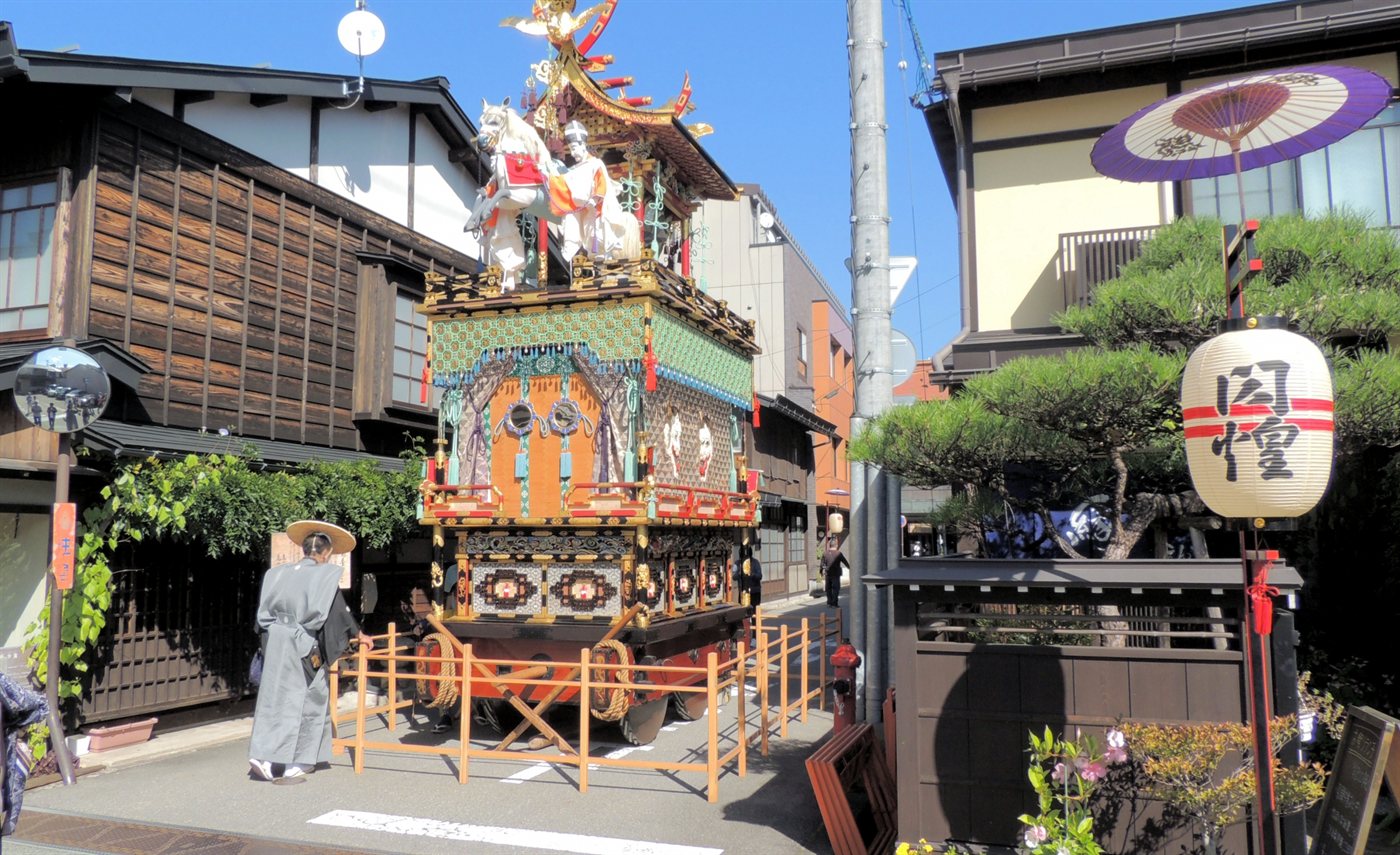 秋の高山祭で高山の町並みを進む屋台