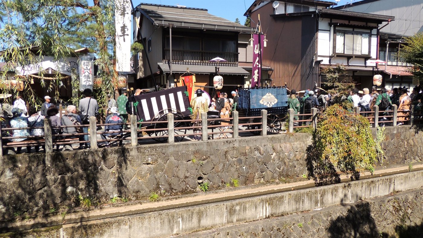 川沿いの通りに並ぶ屋台と、それを見物する大勢の人
