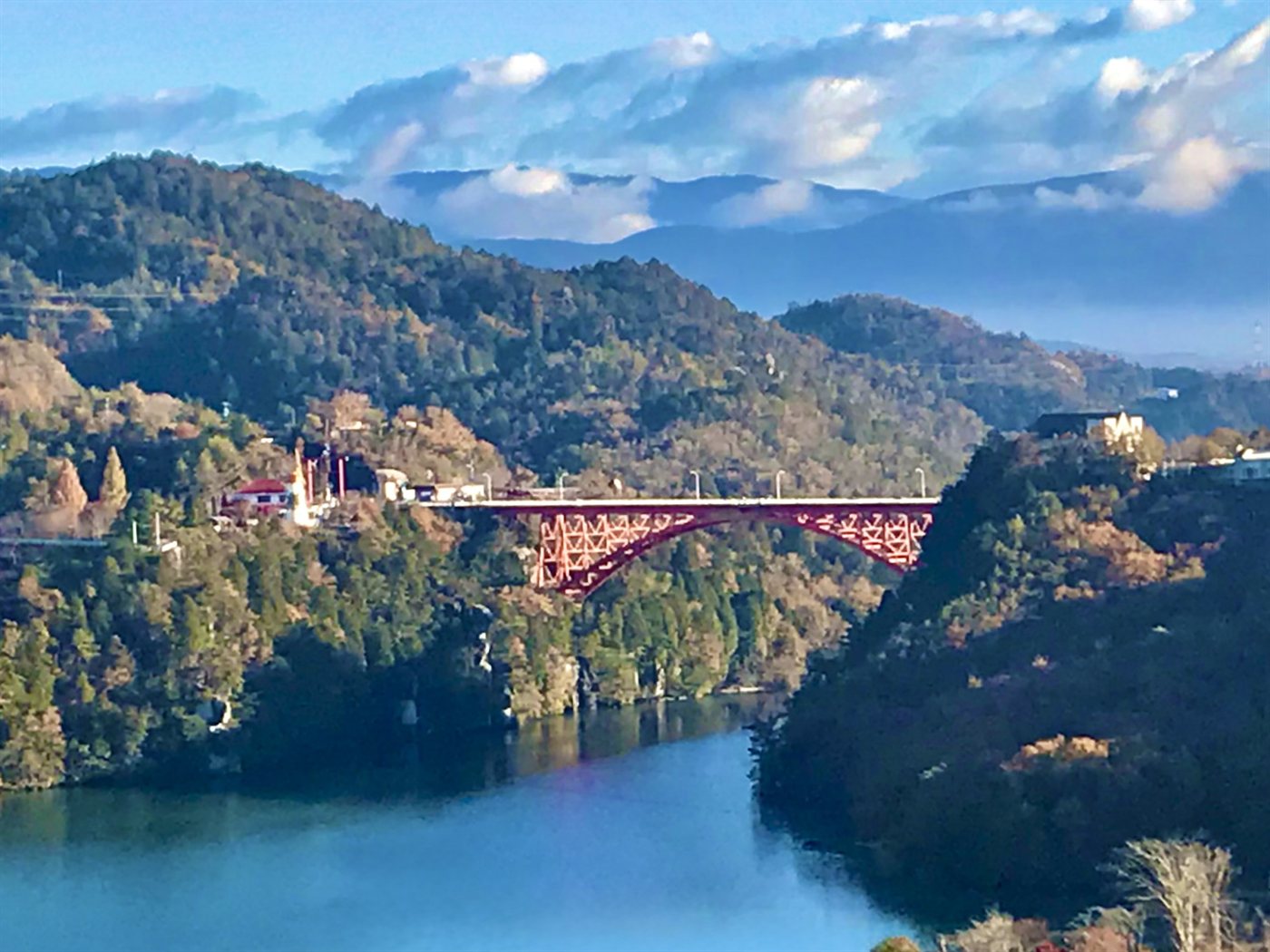 湖にかかる赤い橋と、紅葉が始まった山々(恵那峡)