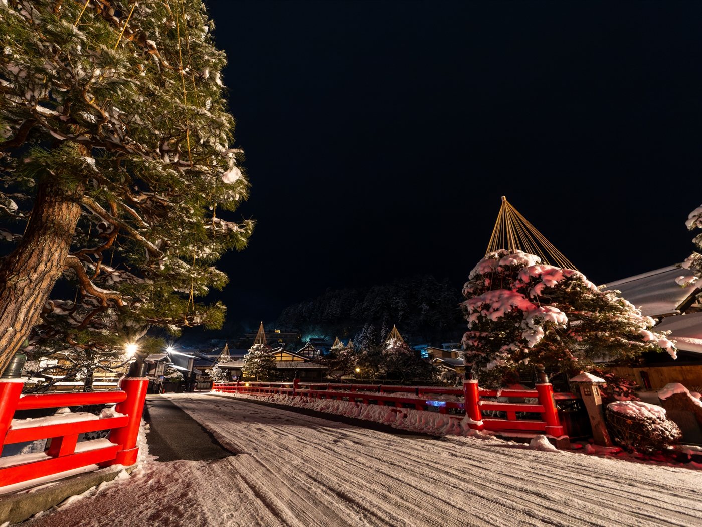 雪が積もった飛騨高山の中橋と、夜の街並み